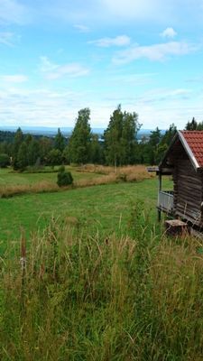 Stuga i fäbodmiljö med utsikt över Siljan