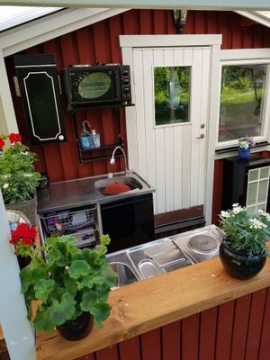 Diskbänk m rinnande varmt/kallt vatten och minikök  m spis o ugn på verandan. Frihetskänsla att stå i uteköket och höra fågelsång, vindens sus och känna naturens dofter.