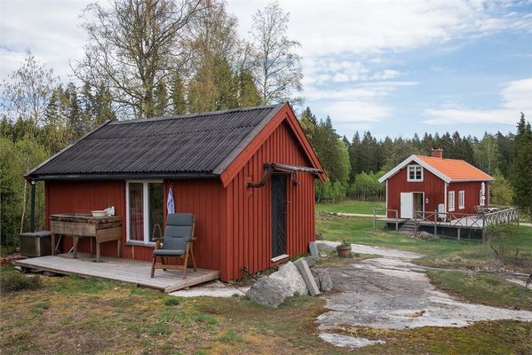 Baksidan av lillstugan med torpet i bakgrunden. Torpet har numer en tillbyggnad.