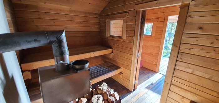 Vedeldad bastu vid sjökanten med terass mot solndgången