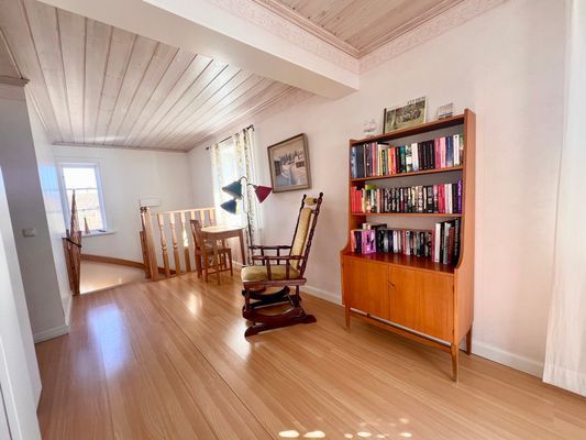 Vardagsrum med bokhylla med böcker att låna, brädspel och pussel.